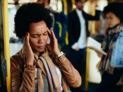 black-woman-holding-her-head-pain-wile-traveling-by-public-transport (1)