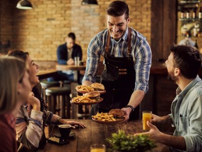 happy-waiter-serving-food-group-cheerful-friends-pub (1)
